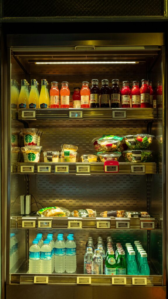 Vibrant store fridge showcasing assorted beverages and fresh salads.